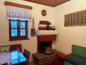 een woonkamer met open haard en een tafel bij Xenonas Achnoulas in Ano Pedina