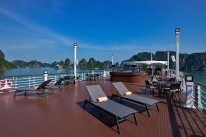 a deck with chairs and tables on a cruise ship at Paradise Legacy Cruise Halong in Ha Long