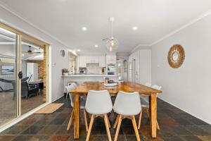 eine Küche und ein Esszimmer mit einem Holztisch und Stühlen in der Unterkunft The Quay To Sussex in Sussex inlet