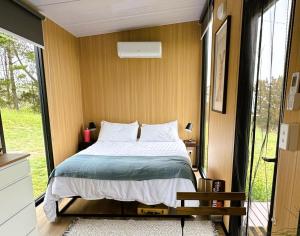 a bedroom with a bed and a large window at Kanimbla Sunsets by Tiny Away in Kanimbla