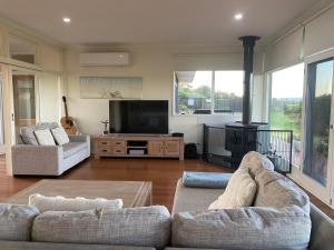 Sandy PointにあるDriftwood Villasの2つのソファと暖炉のあるリビングルーム