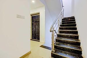 a staircase in a building with black steps and a window at Hotel O Meridian Grand in Shamshabad