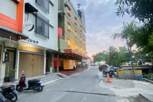 una calle con motocicletas estacionadas al lado de un edificio en RedDoorz at Hotel Memory Batam, en Jodoh