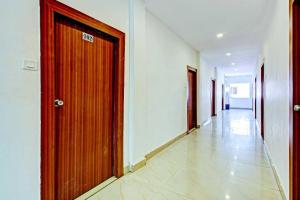 a hallway with a wooden door in a building at Hotel O Meridian Grand in Shamshabad