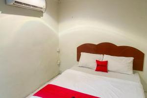 Un dormitorio con una cama con una almohada roja encima. en RedDoorz at Hotel Memory Batam, en Jodoh