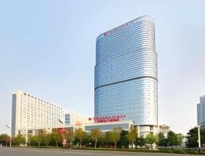 a tall building with a sign on the side of it at Ramada Plaza by Wyndham Chuzhou in Chuzhou