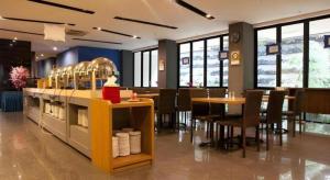 un restaurant avec des tables, des chaises et un comptoir dans l'établissement Indies Style Hotel Bandung, à Bandung