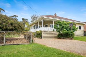 a white house with a fence in front of it at BEACHSIDE GETAWAY DROMANA in Dromana