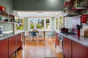 a kitchen with a long counter with a table and chairs at BEACHSIDE GETAWAY DROMANA in Dromana