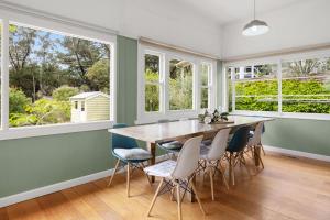 a dining room with a table and chairs and windows at BEACHSIDE GETAWAY DROMANA in Dromana +18 photos