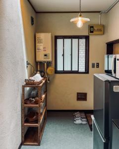 a kitchen with a refrigerator and a microwave at Hostel Hana An in Tokyo +45 photos