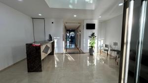 an office lobby with a hallway with a table and chairs at Edificio La Rue- frente al mar in Piriápolis