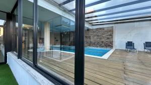 a house with a swimming pool through a window at Edificio La Rue- frente al mar in Piriápolis