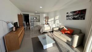 a living room with a couch and a table at Edificio La Rue- frente al mar in Piriápolis
