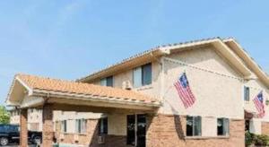 ミドルタウンにあるSuper 8 By Wyndham Franklin/Middletown Areaの前二本のアメリカ旗を掲げた建物