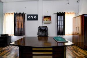 una oficina con un escritorio de madera y una silla en SPOT ON Hotel Gold Inn, en Bheta