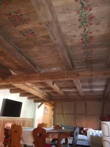 a room with wooden ceilings and a table and a couch at Gite de traditions et charme Chez Montze in Hoerdt