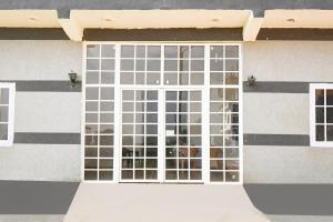 una puerta con una ventana en el lateral de un edificio en SPOT ON Hotel Gold Inn, en Bheta