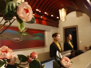 NanjiantaにあるLangfang Ovation Hotelの鏡前のピンクのバラの花瓶 +217枚の写真