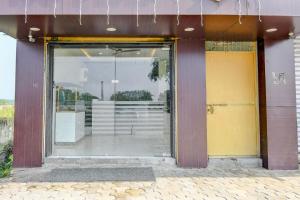 a glass door of a building with a reflection in it at Hotel O S-Square in Bhadrak