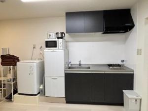 a kitchen with a sink and a microwave and a refrigerator at Newly Renovated 2025 秋リフォーム済 RC205 in Tokyo