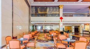 TiantangweiにあるFenggang Gladden Hotelの建物内のテーブルと椅子のある待合室