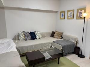 a living room with a couch and a coffee table at Newly Renovated 2025 秋リフォーム済 RC205 in Tokyo