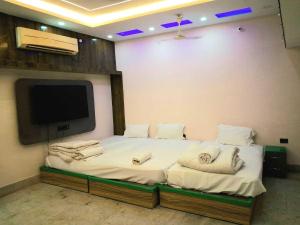 a bedroom with a bed with a tv on the wall at Hotel O Raj Mahal INN in Gulzārbāgh