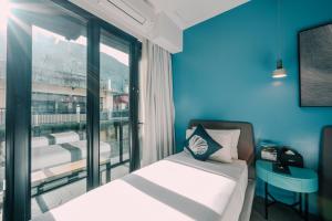 a bedroom with a bed and a large window at H Hotel El Nido - Vegan Friendly Hotel Managed by H Hospitality Group in El Nido