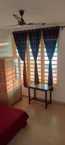 a living room with a table in front of some windows at Ludu guest house in Arambol +19 photos