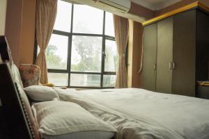 a bedroom with a bed and a large window at MelInn - Lalitpur in Bākhri Kharka