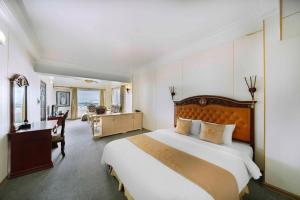 ハイフォンにあるClassic Hoang Long Hotelの大きなベッドと机があるホテルの部屋 +154枚の写真