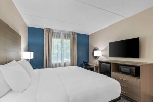 a hotel room with a bed and a flat screen tv at Quality Inn Shepherdstown in Shepherdstown