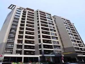 a large apartment building with cars parked in front of it at Oriental Hotel in Dongguan