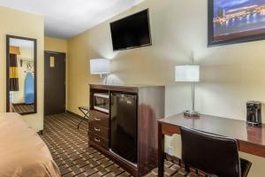 a hotel room with a desk and a tv at Quality Inn Grand Rapids Near Downtown in Grand Rapids
