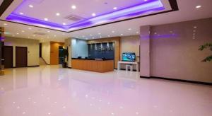 a large lobby with a television in a building at Ewha Hotel in Jeju