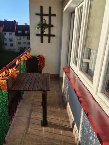 a wooden bench on a balcony with a cross on the wall at Zielony Balkon in Sanok
