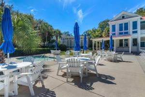 a group of tables and chairs with blue umbrellas at Inn at I'On, an Ascend Collection Hotel in Charleston