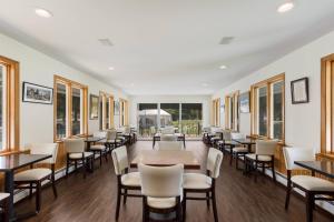 a dining room with tables and chairs and windows at The Palmer House Resort, an Ascend Collection Hotel in Manchester