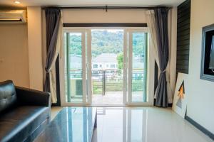 Ban SireにあるLulu Hotel at The Glasshouse Lion Caféのリビングルーム(ソファ付)、大きなスライド式ガラスドア