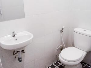 a bathroom with a white toilet and a sink at RedDoorz near Juwata 3 Airport Tarakan in Karanganyar
