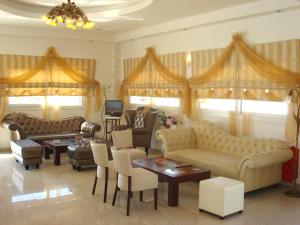 a living room with couches and chairs and a television at Royal Beach Hotel in Arkasa +24 photos