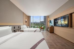 a hotel room with two beds and a large window at Qingdao Huangdao Golden Beach Art Dragon Hotel in Yantaiqian +83 photos