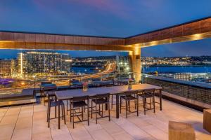a balcony with tables and chairs and a view of a city at Cambria Hotel Washington DC Navy Yard Riverfront in Washington
