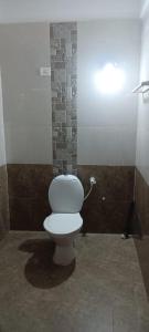 a bathroom with a white toilet in a room at Ludu guest house in Arambol