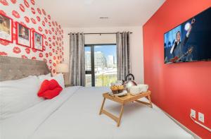 a bedroom with a large bed with a red wall at Hyve - Neon Lights - Pool & Gym - Walk to Broadway in Nashville +84 photos