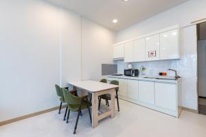 a kitchen with white cabinets and a table and chairs at Gapyeong Ttongkkodeuruisuda Pension in Oebang-ni