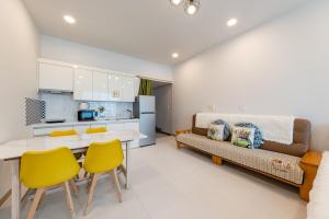 a kitchen and living room with a table and yellow chairs at Gapyeong Ttongkkodeuruisuda Pension in Gapyeong +17 photos