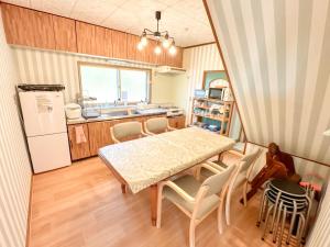 a kitchen and dining room with a table and chairs at リニューアル天然温泉マンイの湯 in Shiraoi