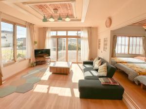 a large living room with a bed and a couch at リニューアル天然温泉マンイの湯 in Shiraoi